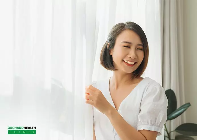 Smiling lady holding the curtain